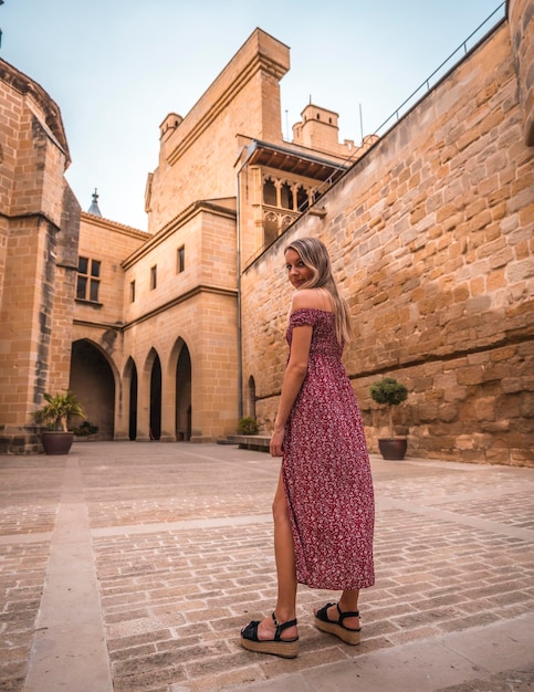 Retrato de uma mulher loira em um castelo medieval aproveitando as férias