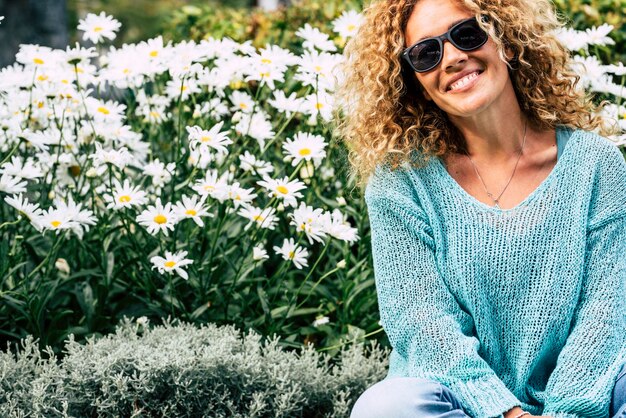 Foto retrato de uma mulher madura sorridente sentada contra plantas