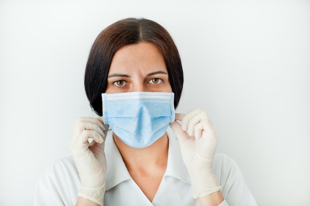 Retrato de uma mulher médico em luvas e máscara médica