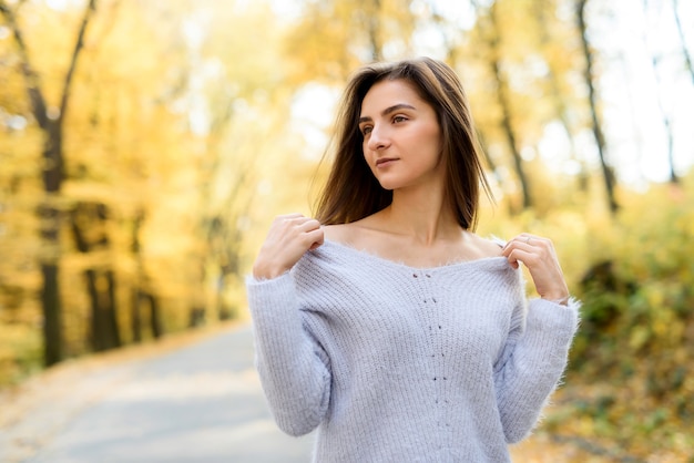 Retrato de uma mulher morena com roupas casuais no outono park. Cores amarelas em torno de mulher bonita