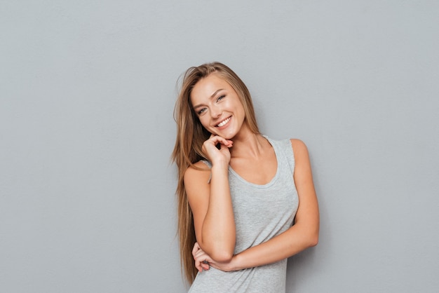 Retrato de uma mulher muito sorridente posando isolada em um fundo cinza