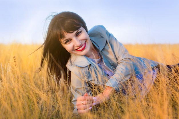 Retrato de uma mulher na grama amarela das estepes