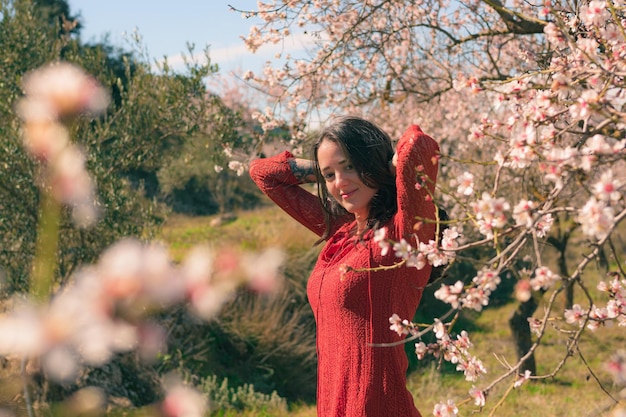 Retrato de uma mulher posando com uma amendoeira e um ambiente de primavera