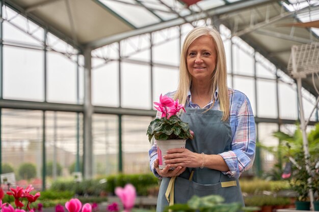 retrato de uma mulher proprietária de uma loja de plantas olhando para a câmera