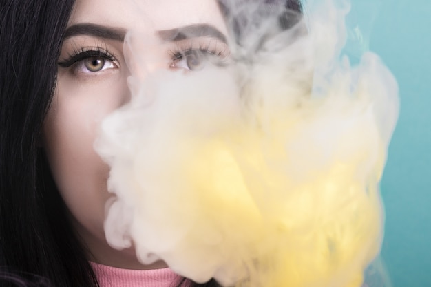 Foto retrato de uma mulher que fuma um cigarro eletrônico