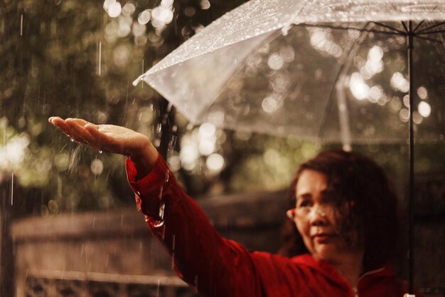 Foto retrato de uma mulher segurando um guarda-chuva durante a estação chuvosa