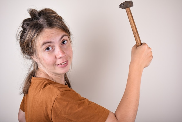 Foto retrato de uma mulher segurando um martelo