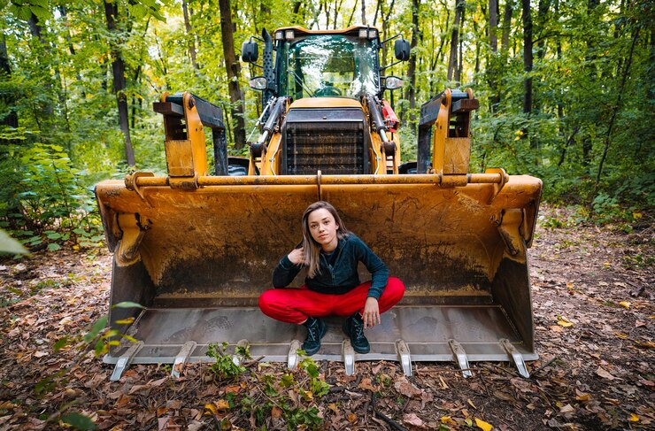 Foto retrato de uma mulher sentada em uma escavadeira na floresta