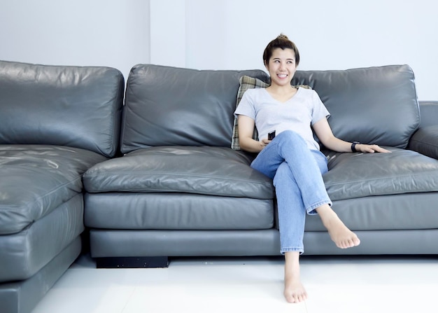 Retrato de uma mulher sentada no sofá em casa