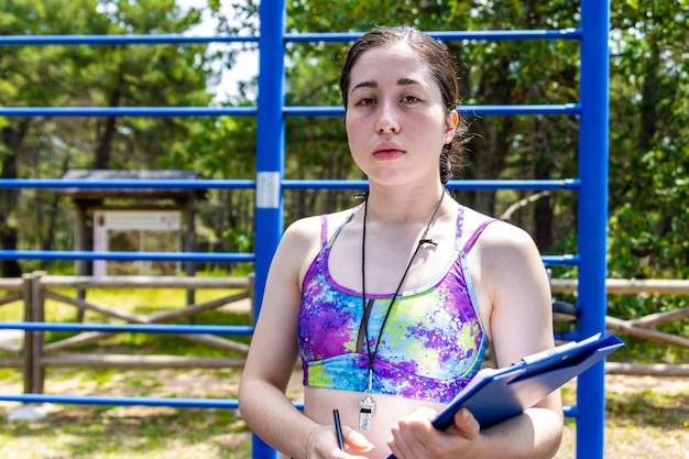 Retrato de uma mulher séria de personal trainer olhando para a câmera Ocupação profissional Melhoria pessoal preparação para teste de treinamento físico