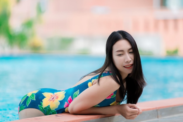 Retrato de uma mulher sexy asiática na piscinaA Tailândia tem uma forma de corpo esbeltoConceito de mulher saudávelModa de biquíni verão