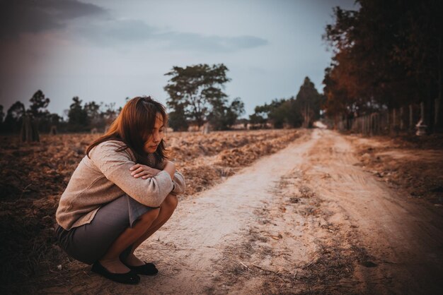 Retrato de uma mulher solitária sozinha em um campo Estilos de filtro vintage ela desgosto do conceito de menina apaixonada no estilo vintage do pôr do sol
