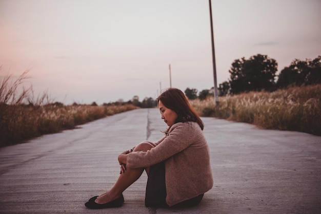 Retrato de uma mulher solitária sozinha em um campo Estilos de filtro vintage ela desgosto do conceito de menina apaixonada no estilo vintage do pôr do sol