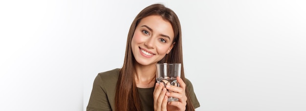 Retrato de uma mulher sorridente caucasiana atraente isolada em uma foto de estúdio branca bebendo água