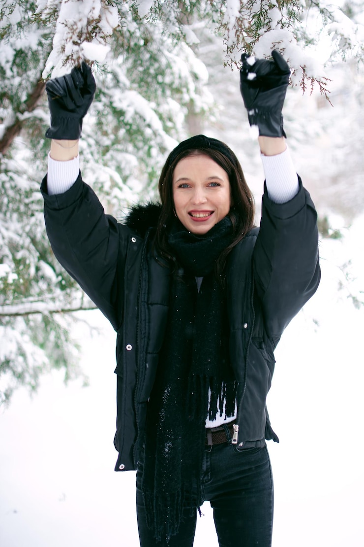 Foto retrato de uma mulher sorridente de pé contra a neve