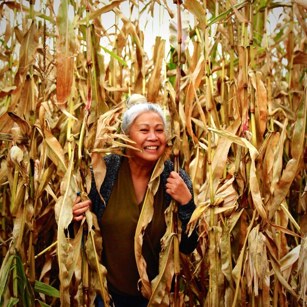 Retrato de uma mulher sorridente de pé junto a plantas