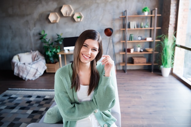 Foto retrato de uma mulher sorridente e feliz no fim de semana na sala de estar de um apartamento moderno