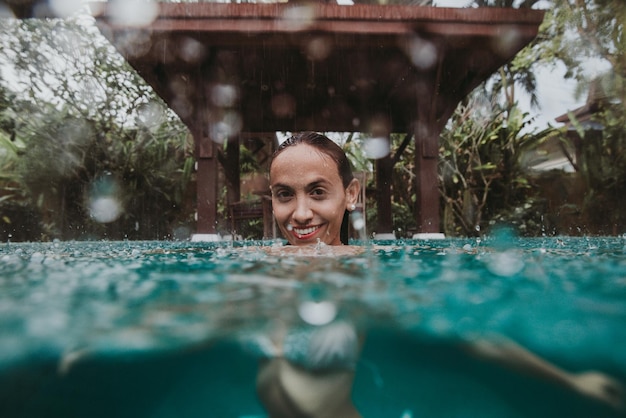 Foto retrato de uma mulher sorridente nadando na piscina