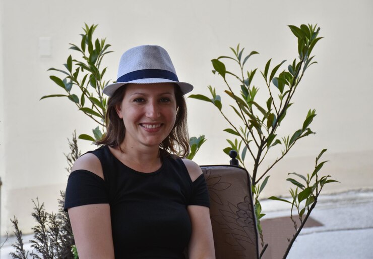 Foto retrato de uma mulher sorridente sentada contra plantas