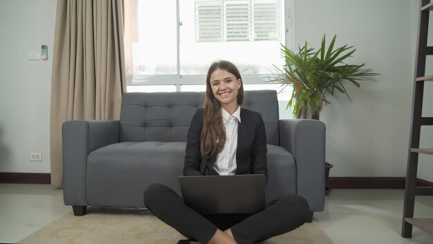 Retrato de uma mulher sorridente sentada no sofá em casa