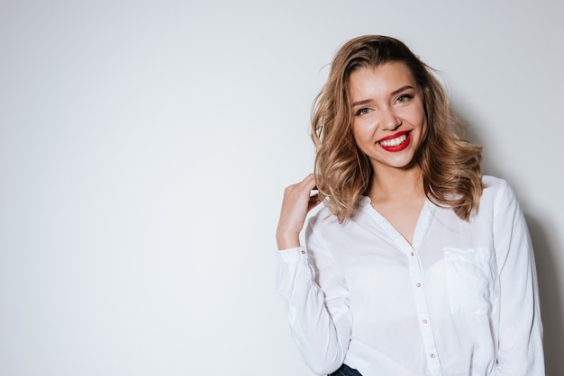 Retrato de uma mulher sorridente sobre uma parede branca