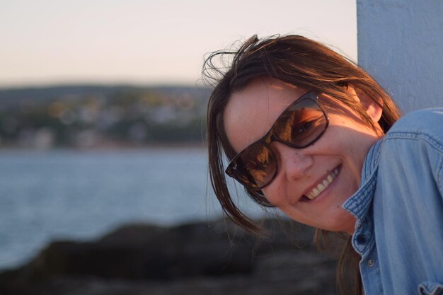 Foto retrato de uma mulher sorridente usando óculos de sol