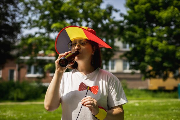 Retrato de uma mulher usando um chapéu de bandeira belga em um piquenique