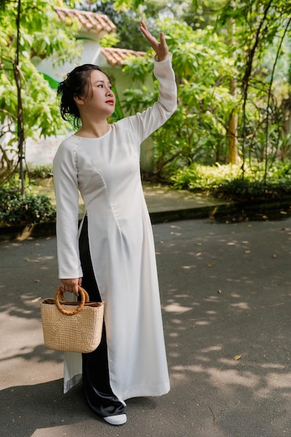 Retrato de uma mulher vietnamita vestindo o traje nacional ao dai no parque