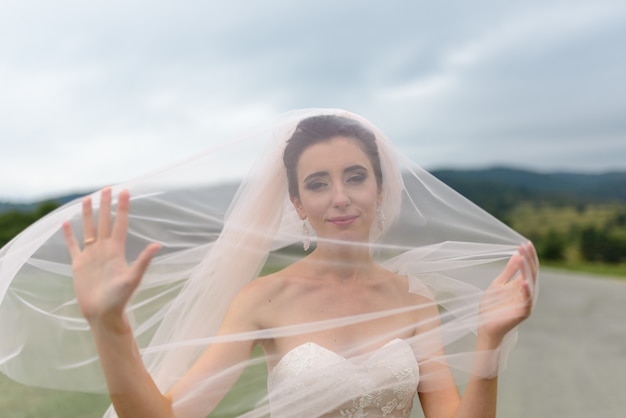 Foto retrato de uma noiva sob um véu. o vento sopra um véu. fechar-se.