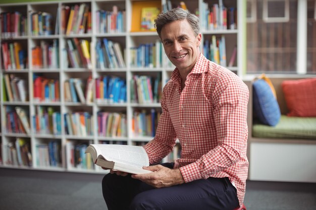 Retrato de uma professora segurando um livro na biblioteca