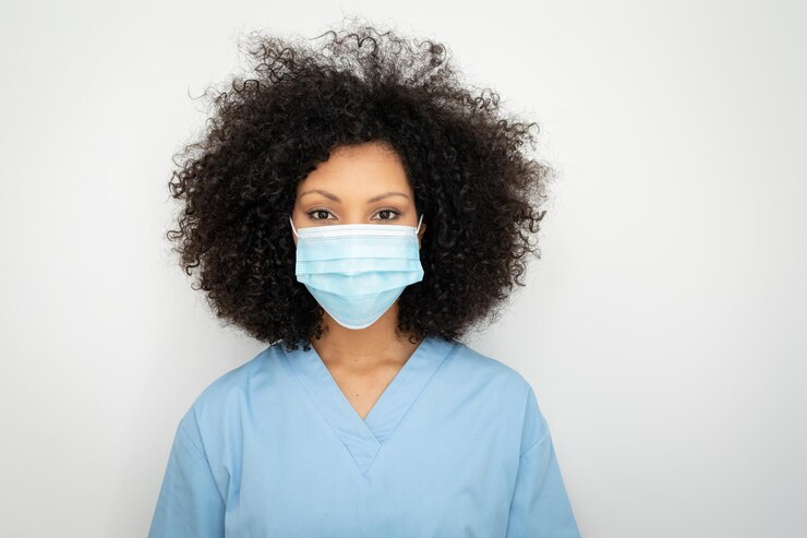 Foto retrato de uma profissional de saúde afro-americana com cabelo afro usando máscara facial, olhando para a câmera. profissão médica, higiene durante a pandemia de coronavírus covid19.