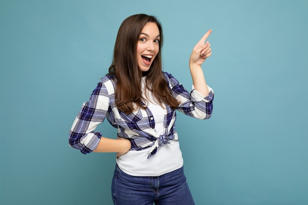 Retrato de uma promotora linda e fascinante apontando para o lado no espaço de cópia para publicidade