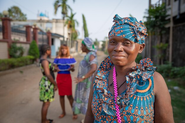 Retrato de uma senhora africana isolada com três mulheres falando ao fundo conceito de mulheres africanas