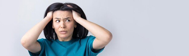 Retrato de uma senhora atraente segurando as mãos na cabeça Expressões e emoções do rosto humano