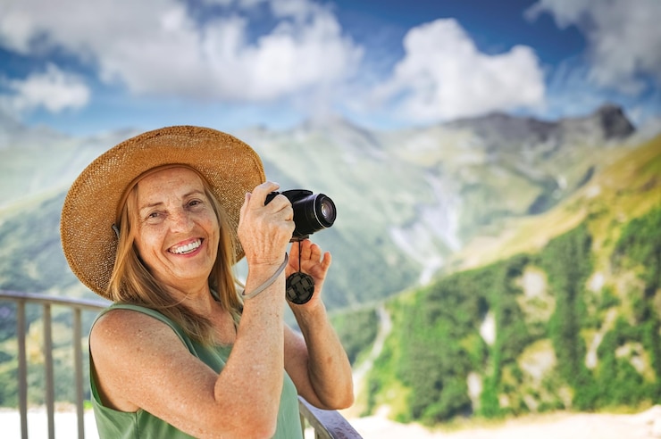 Foto retrato de uma sorridente e feliz turista idosa viajando com uma câmera posando contra o fundo de