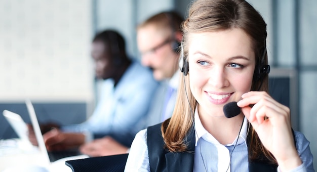 Retrato de uma trabalhadora de call center acompanhada por sua equipe. Operador de suporte ao cliente sorridente no trabalho.