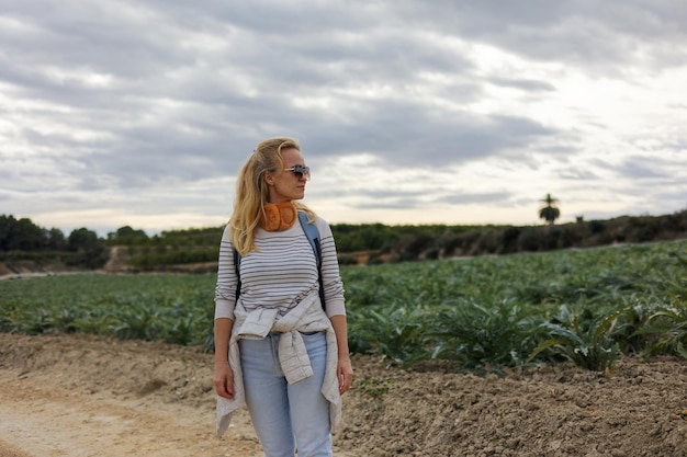 Retrato de uma turista olha para campos agrícolas de alcachofra