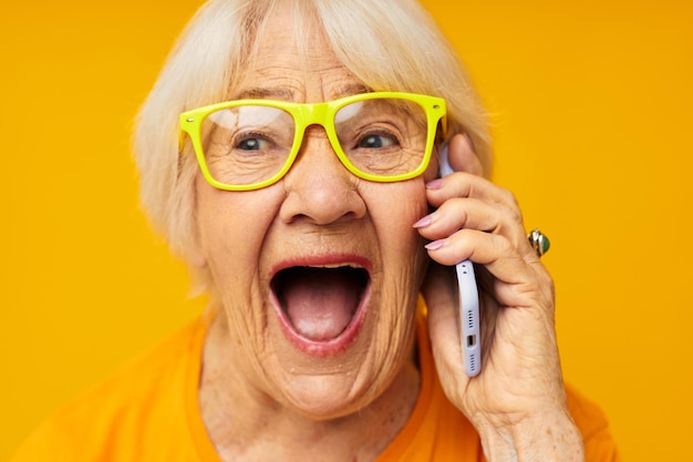 Retrato de uma velha amiga divertida falando sobre as tecnologias de telefone