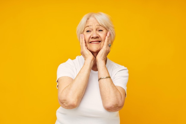 Foto retrato de uma velha amigável em camiseta branca posando fundo isolado divertido