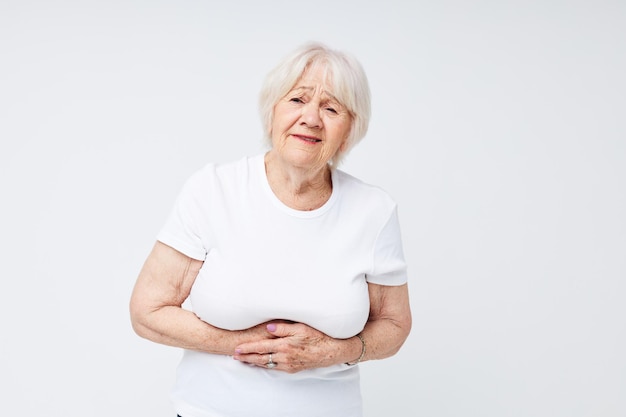 Retrato de uma velha amigável em um fundo claro de camiseta branca