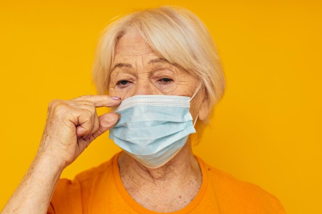 Foto retrato de uma velha amigável na visão recortada da máscara médica de camiseta casual