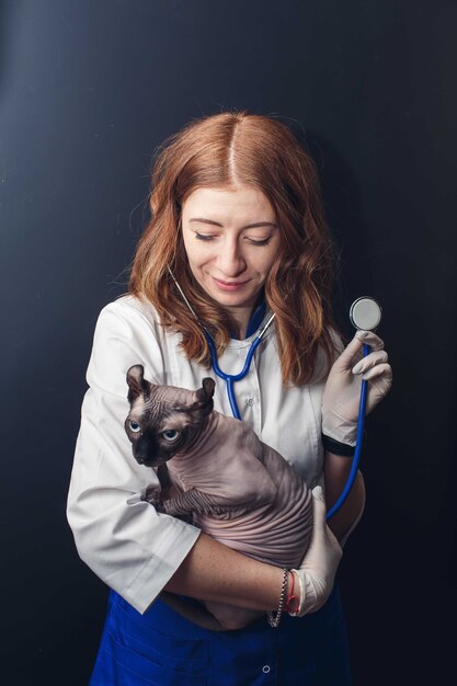 Retrato de uma veterinária segurando um gato esfinge.