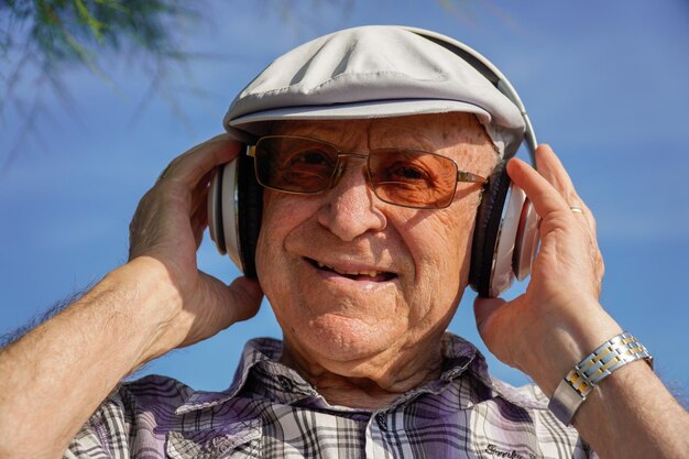 Retrato de velho ouve música em um parque de idosos autênticos
