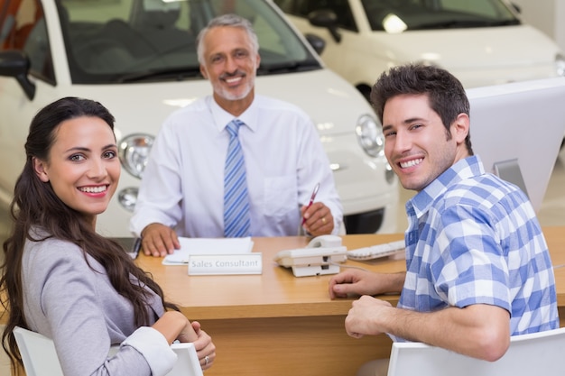 Foto retrato de vendedor sorridente e seus clientes