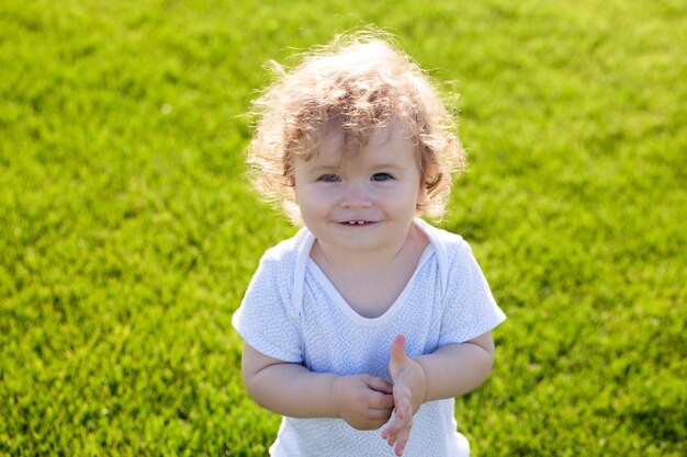 Retrato de verão de menino no gramado