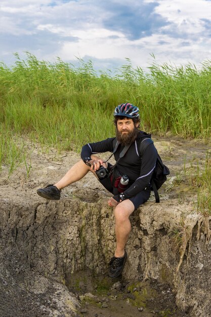 Retrato de verão de um ciclista usando um capacete ao ar livre. Ciclista parado