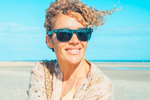 Retrato de verão de uma jovem adulta alegre e feliz com óculos de sol admirando a praia Estilo de vida de férias de férias com mulheres bonitas Turista desfrutando e relaxando no lazer ao ar livre