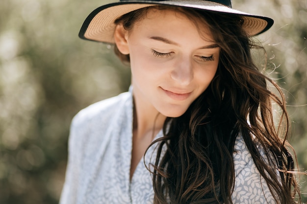 Retrato de verão de uma jovem mulher feliz no chapéu