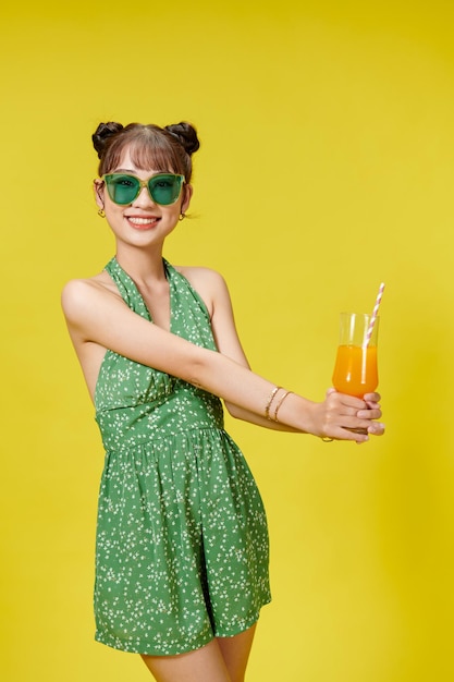 Retrato de verão de uma linda mulher asiática segurando uma bebida de suco de fruta