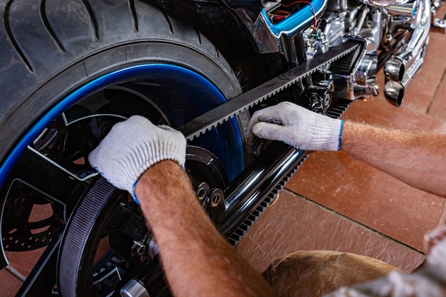 Retrato de vista lateral do homem que trabalha na garagem consertando motocicleta Mãos fechadas